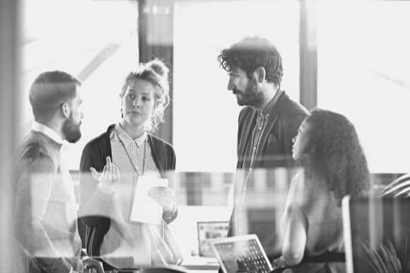 Manager ensuring proper employee classification while meeting with coworkers