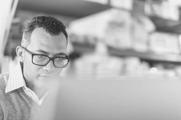 A business systems analyst hard at work checking a computer system.