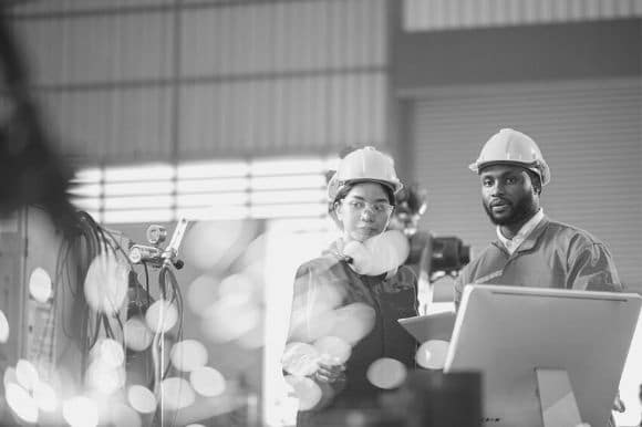 Two manufacturing engineers observing a production facility.