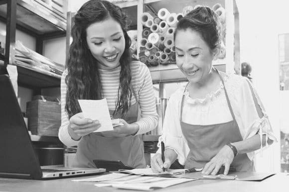 A payroll clerk going over documents and records with her manager.