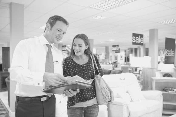 A sales assistant helps a customer decide on her purchase.