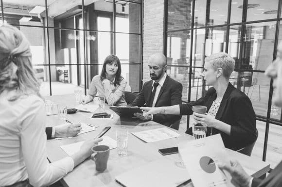 A sales manager convening a meeting with her sales staff.