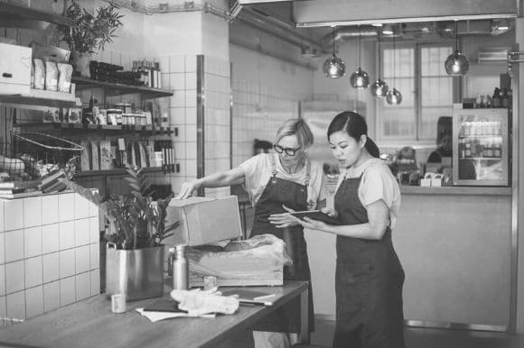 Two hourly workers at a retail shop restocking the showroom.