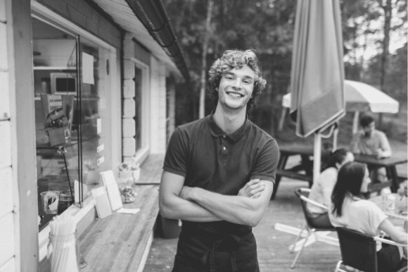 Summer worker smiling at camera on patio