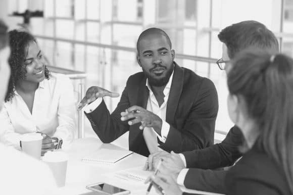 An office leader engages his colleagues in conversation.