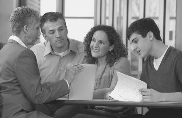 Admissions counselor meeting with students in office