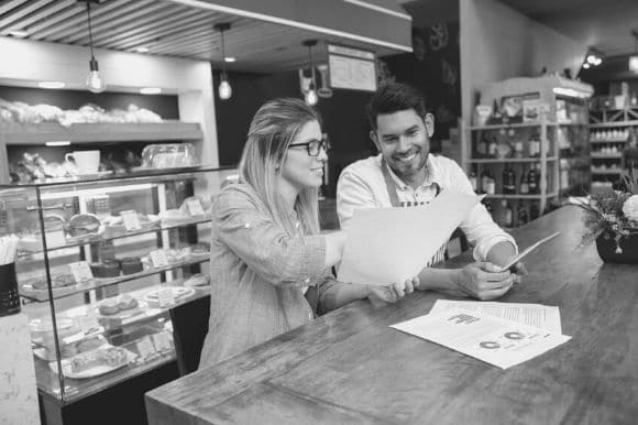 Assistant store manager talking to employee at counter