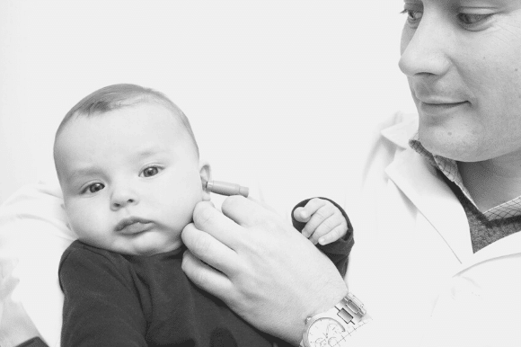 An audiologist checking a baby's hearing.