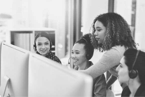 A call center operations manager works with her team of customer service representatives.