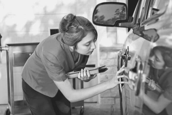 Claims specialist evaluating damaged vehicle