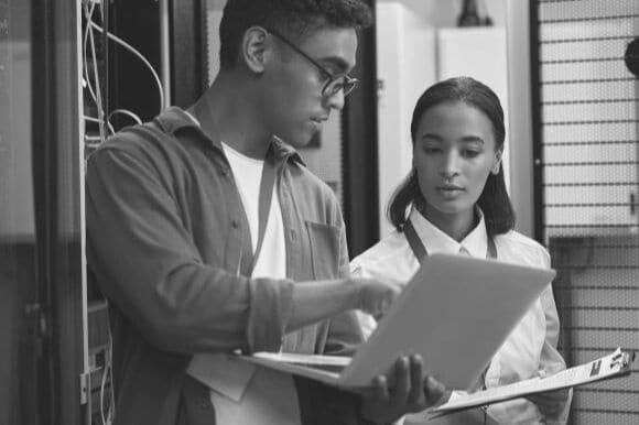 Database manager working on computer with employee