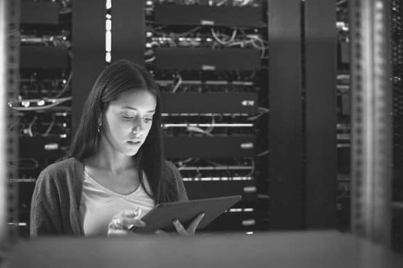 An IT specialist standing in a server room, running diagnostic tests.