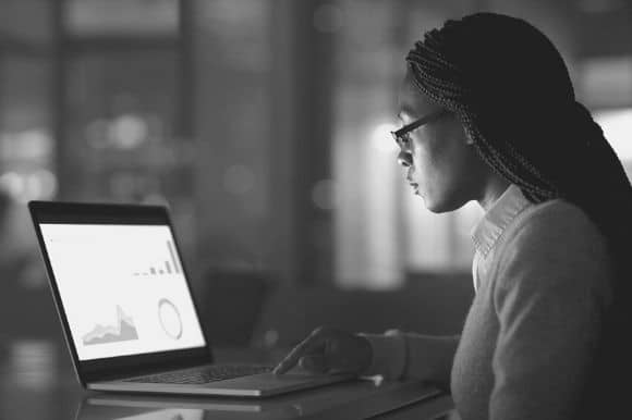 An operations analyst at work, looking at data and graphs.