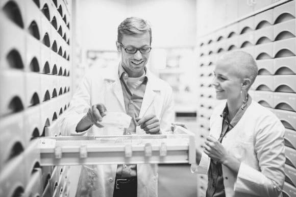 Two pharmacists taking inventory of pharmacy stock.