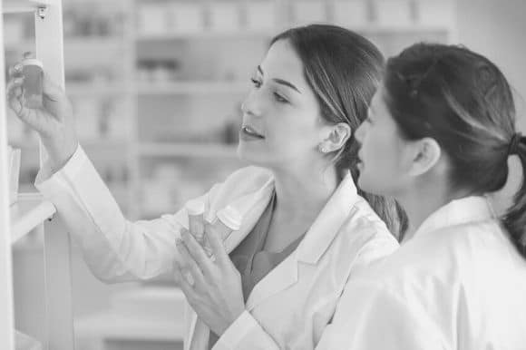 A pharmacy technician assists the pharmacist with restocking the shelves.