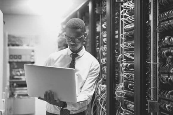 Telecommunications specialist looking at network server in office