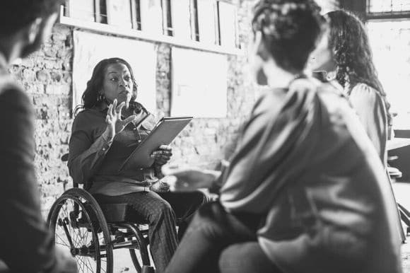 Good small business leadership, as demonstrated by a manager meeting with her colleagues.