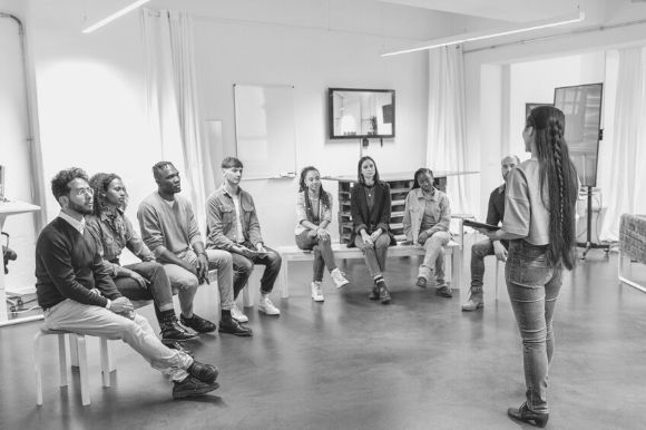 A company founder engaging in some leadership storytelling as she addresses her new employees.