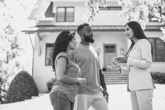 A real estate agent shows a house to a couple.