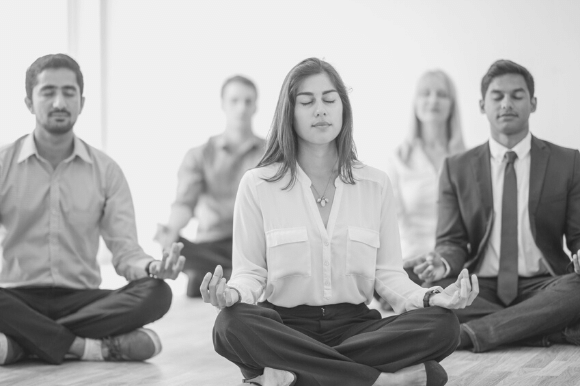 Employees doing yoga together as part of a comprehensive set of employee wellness benefits.