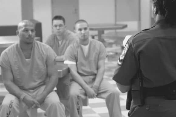 Correctional officer talking to inmates in prison