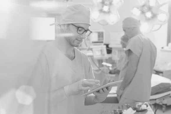 Nurse practitioner checking records on handheld device.