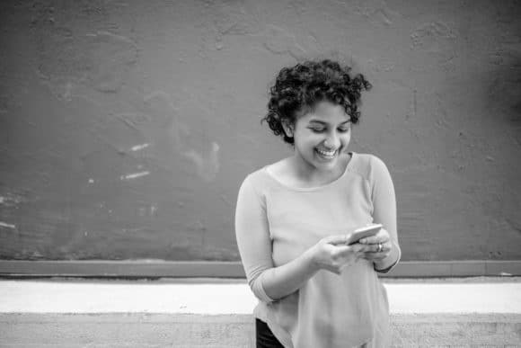 Woman smiling at her smart phone.
