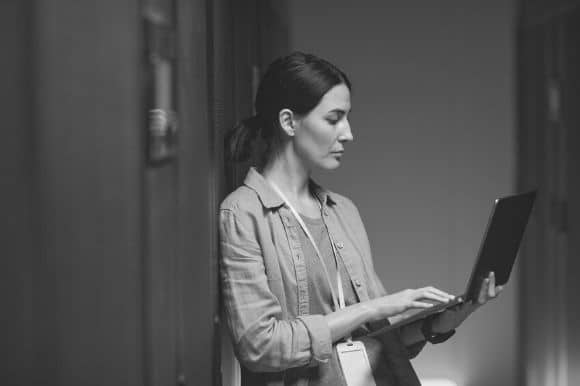 Data scientist, standing with her laptop, reviewing a project.