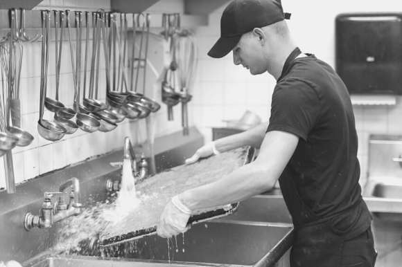 A dishwasher cleaning sheet pans.