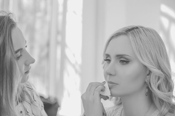 Esthetician applying makeup to a client's face.