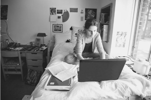 Resident assistant working on laptop in dorm