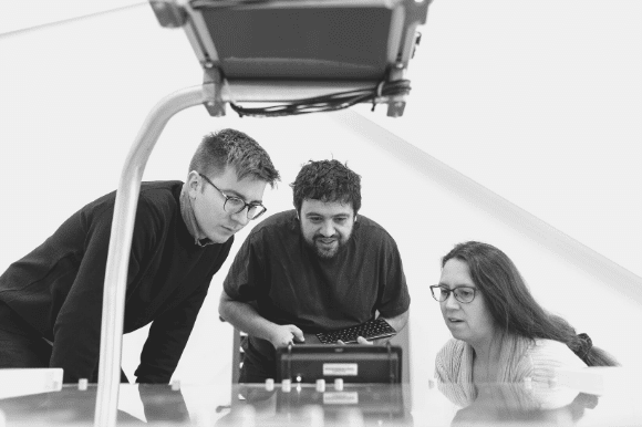 Engineering manager inspecting a piece of machinery with his colleagues.