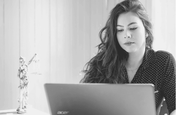 Lawyer reviewing her case or conducting research on a laptop computer.