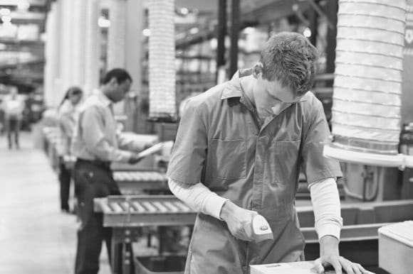 Package handler scanning an item in a warehouse for delivery.