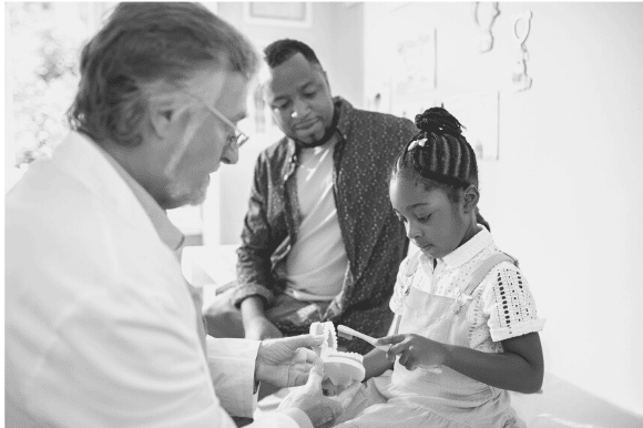 Pediatrician meeting with a patient and her father.