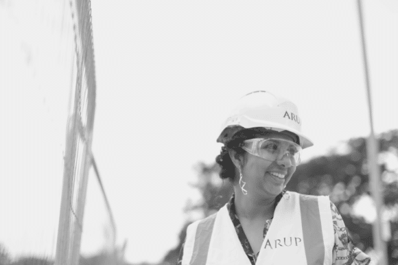 Construction superintendent wearing a hardhat and vest, overseeing a project.