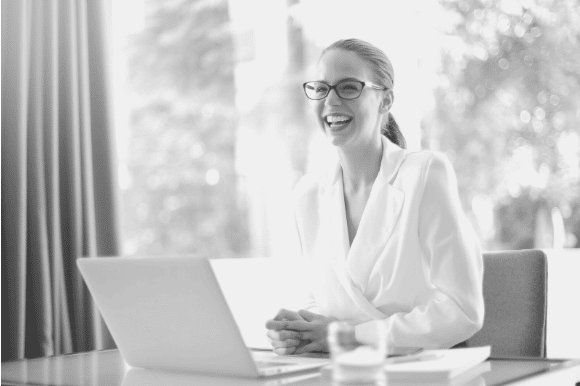 Executive director smiling and sitting behind her desk.