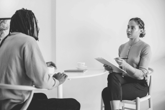 A mental health counselor sits with a patient for a discussion and therapy session.