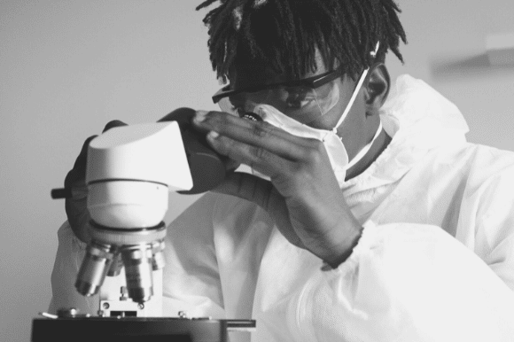 Pathologist examining a biopsy sample under a microscope.