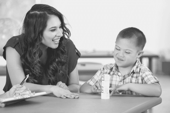 School psychologist sitting with a student.