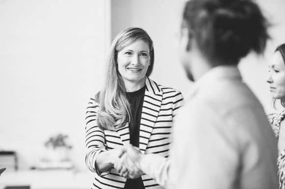 As part of a company's returnship program, an employee shakes her manager's hand as she's welcomed back into the workforce.