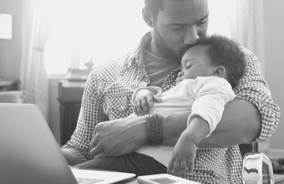 An employee spending some quality time with his new baby after taking paid parental leave.