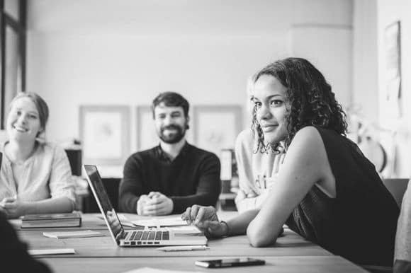 Employees at a high-growth startup, sitting around a conference room table and discussing their equity compensation.