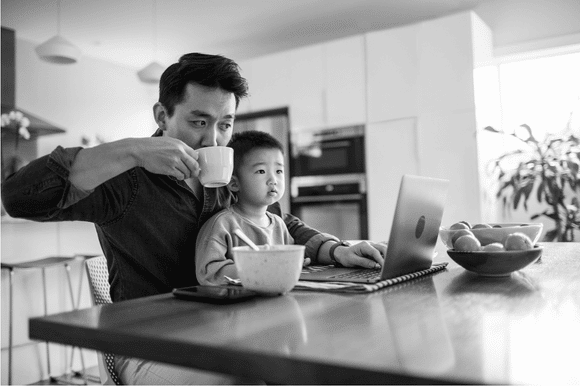 A dad and his child at the computer.