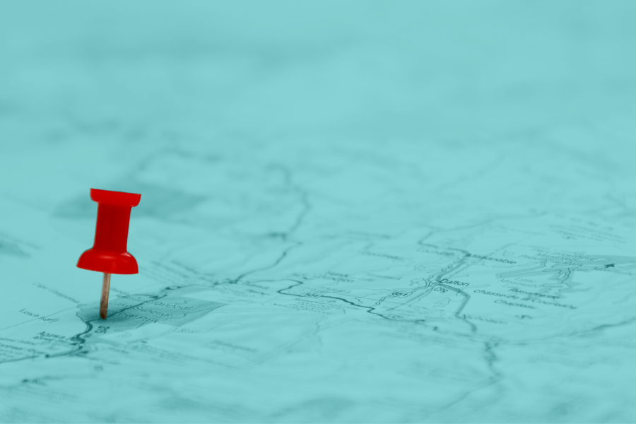 map with a teal blue overlay with red pin on top