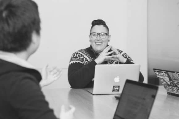 Manager behind a laptop, interviewing a job candidate.