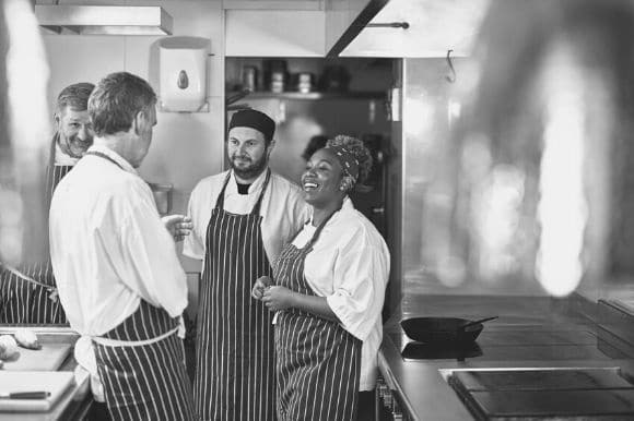 A group of kitchen employees meeting with their manager.