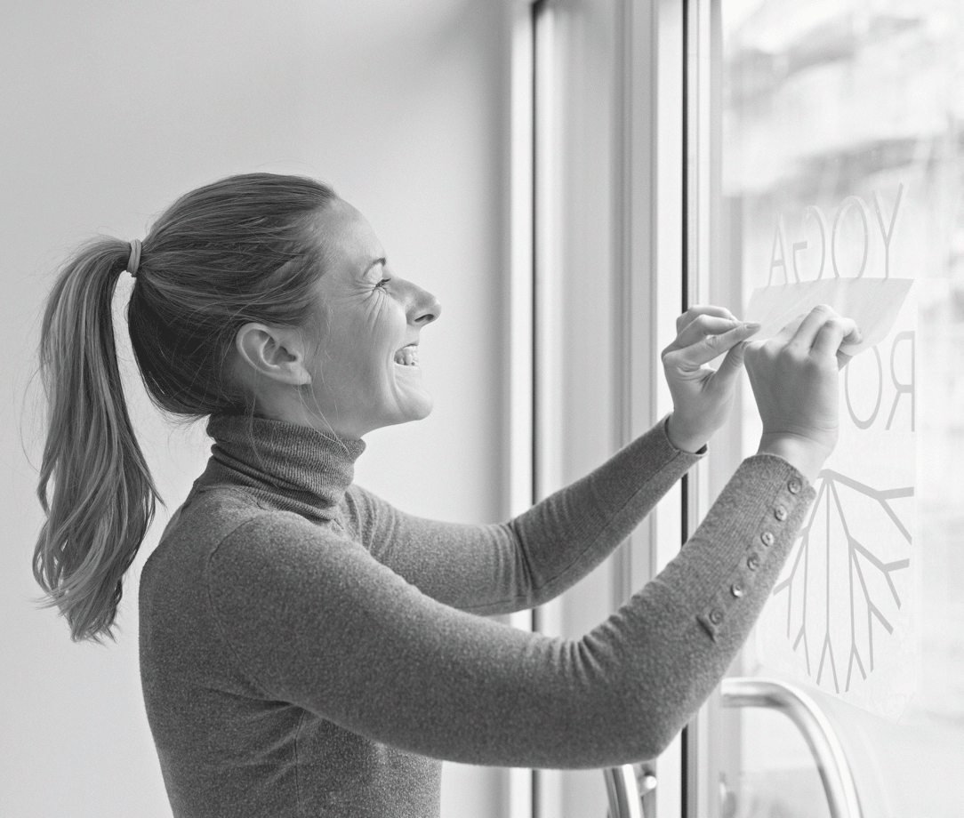 Woman applying decal to window