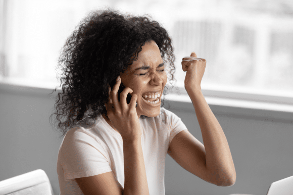 A woman is very happy as she hears on the phone she was won her dream job