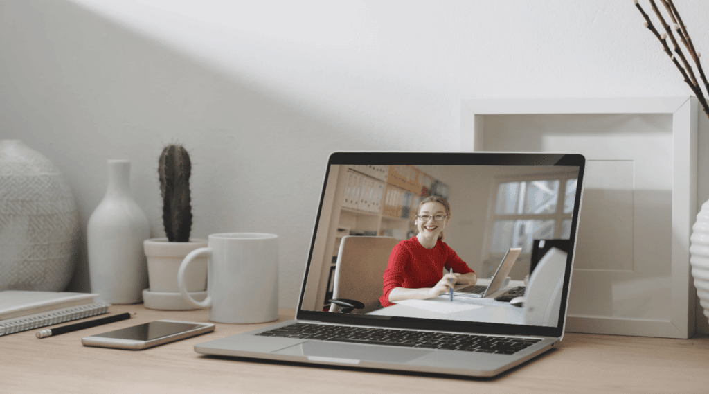 A woman is being interviewed remotely, she appears n a laptop screen